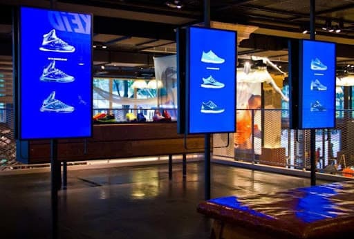 NIKEiD retail environment — blue-lit vertical kiosk displays in a Nike store
